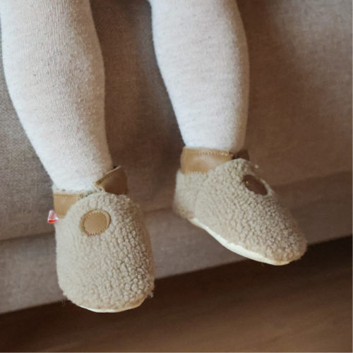 Photo des chaussons enfant Bouclettes café portés par un bébé.