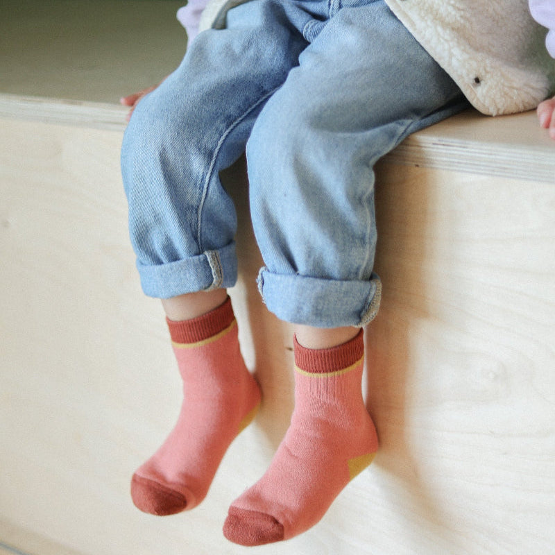photo des chaussettes sans couture unies rose et terracotta épaisses portées par un enfant