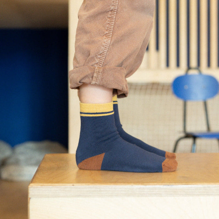 chaussettes sans couture unies marine et ocre épaisses portées par un enfant