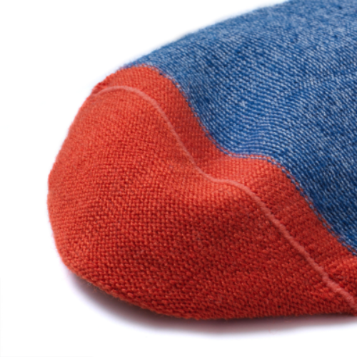 Détail de la couture intérieure des chaussettes rouge et bleu.