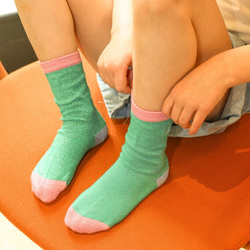 chaussettes unies paillettes vert et rose portées par un enfant