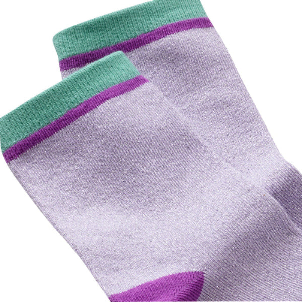 Vue zoomée d'un détail des chaussettes unies paillettes violet et vert.