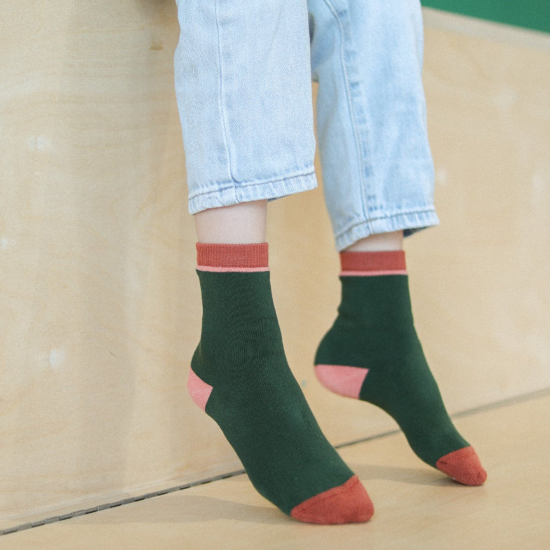 chaussettes sans couture unies vert et rose épaisses portées par un enfant