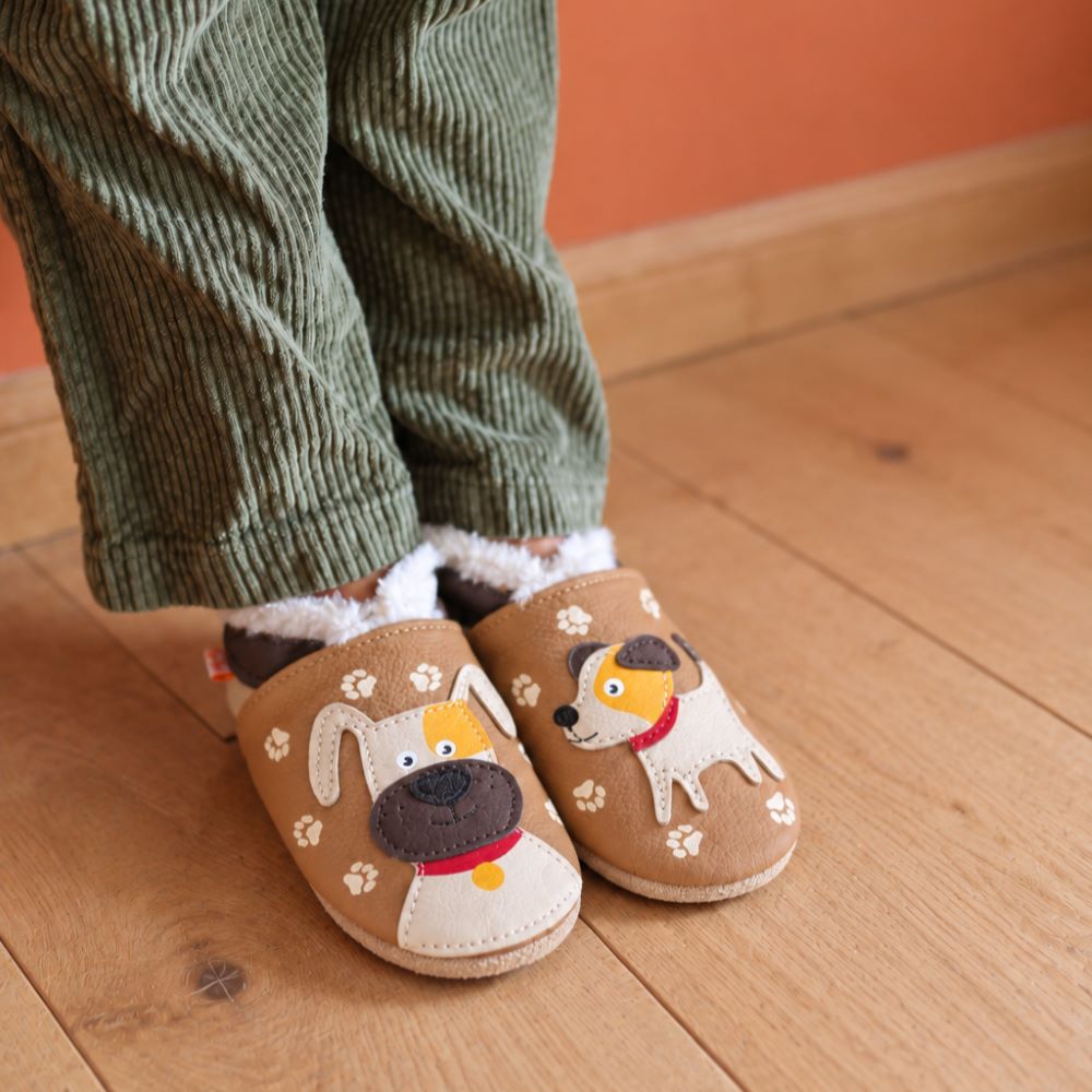 Photo de face des chaussons enfant fourrés en cuir souple Adrien le chien portés par un enfant.