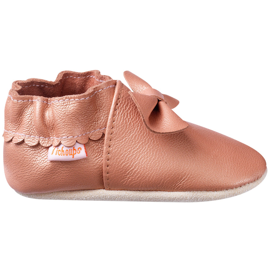 Vue de profil des chaussons cuir souple bébé Nœuds rose irisé.