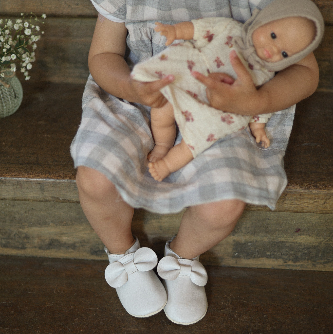 photo chaussons blanc avec nœud portés par un enfant