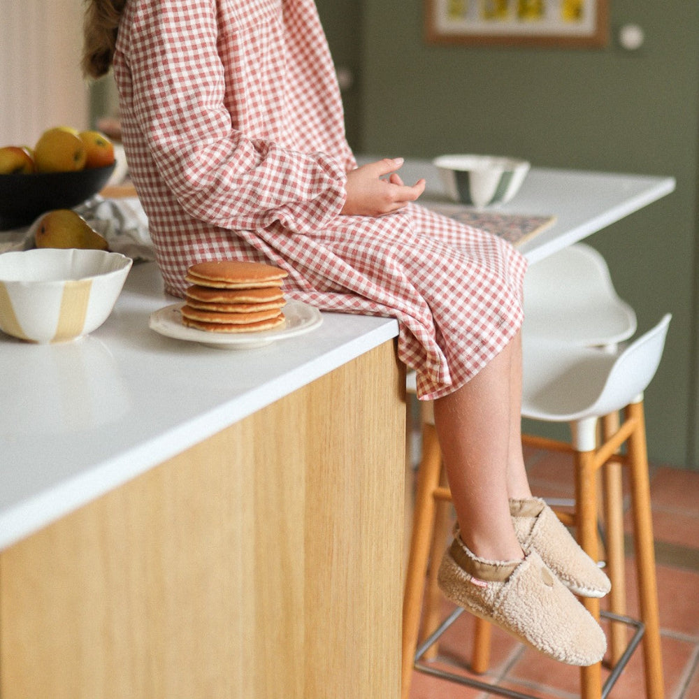 Photo des chaussons enfant Bouclettes café portés par une enfant dans une ambiance hivernale.