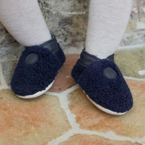 Photo des chaussons souple enfant Bouclettes marine portés par un bébé.