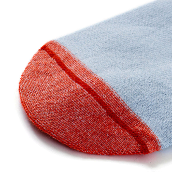 Chaussettes sans couture unies bleu gris avec détails rouge sur l'envers, vue de la couture plate.