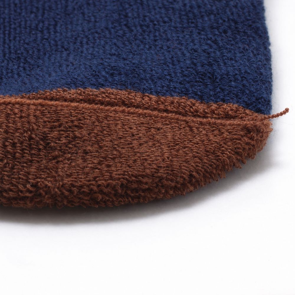 Couture intérieure plate des chaussettes sans couture unies marine et ocre épaisses .