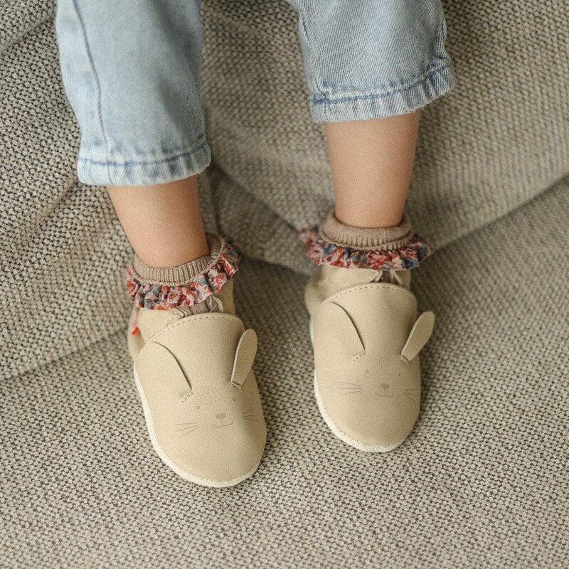 chaussons cuir souple avec petite tête de lapin beige, portée par un bébé 