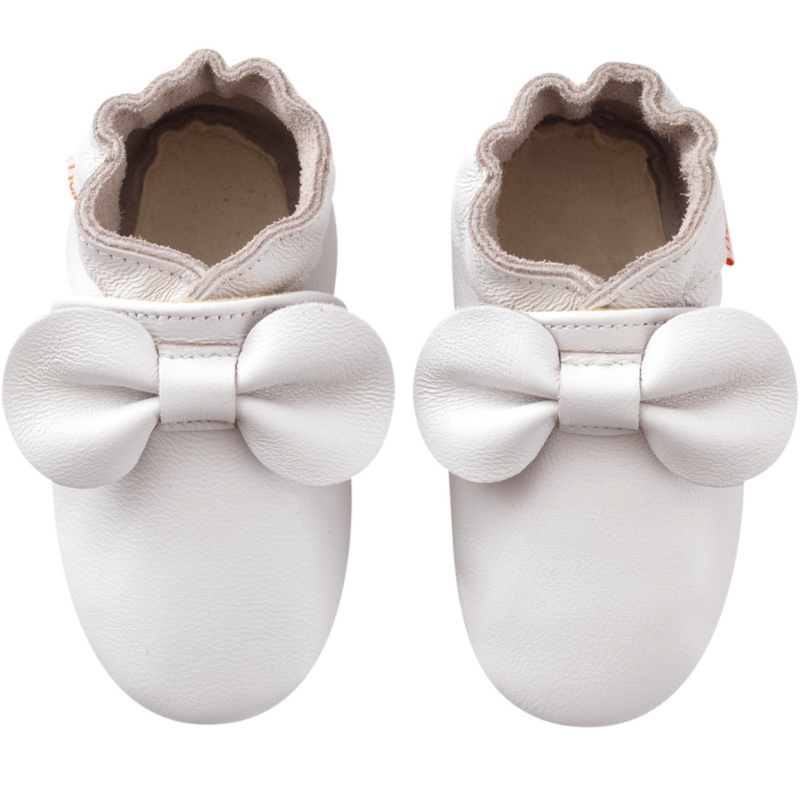 chaussons bébé en cuir blanc avec un nœud vue de face