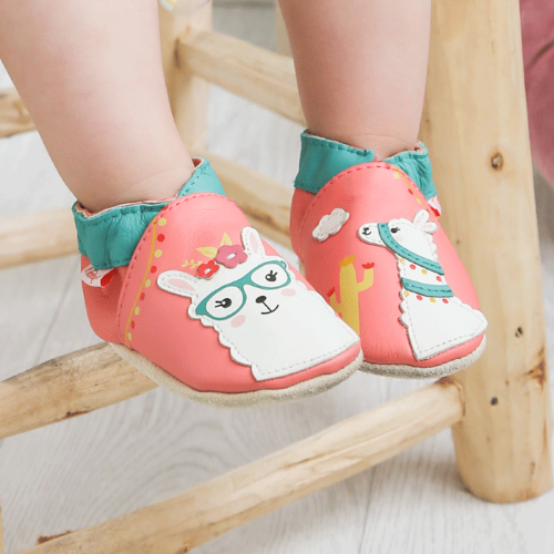 Photo des chaussons bébé cuir souple Lena le lama portés par un bébé.