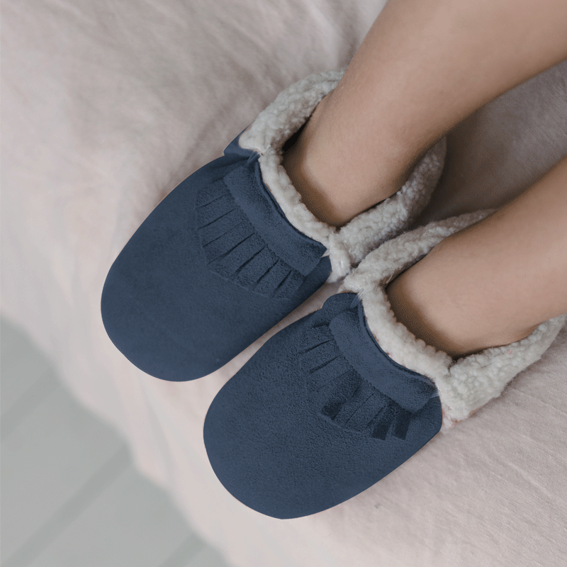 Chaussons cuir fourrés à franges coloris bleu marine portés par un enfant