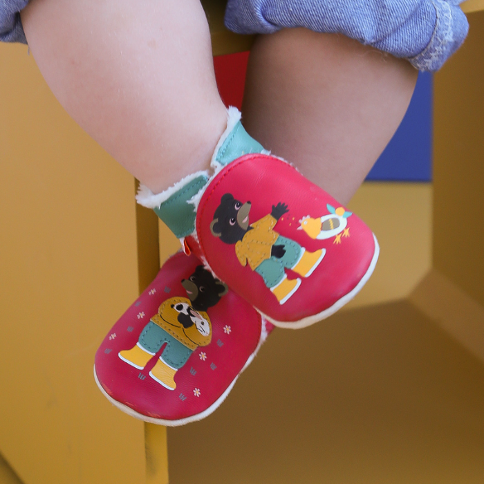 Chaussons cuir souple fourre petit ours brun à la ferme portés par un bébé