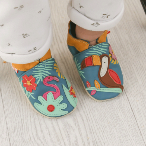 Photo des chaussons cuir souple bébé Soizic sous les tropiques portés par un bébé.