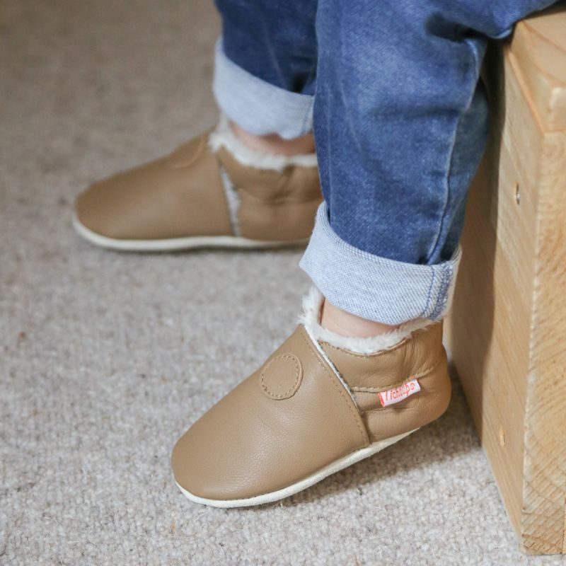 Chaussons cuir souple unis fourrés café portés par un enfant